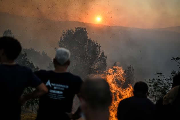 Villagers watch the progression of a wildfire as it approaches Zambujeiro village in Cascais on July 25, 2023.