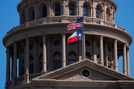 FILE PHOTO - The U.S flag and the Texas State flag fly over the Texas State Capitol in Austin, Texas, U.S. on March 14, 2017. REUTERS/Brian Snyder/File Photo