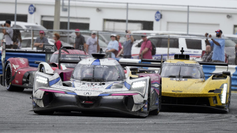 Simon Pagenaud, of France, in an Acura ARX-06, leads Sebastien Bourdais, of France, right, in a Cadillac V-LMDh through a horseshoe turn during the Rolex 24 hour auto race at Daytona International Speedway, Sunday, Jan. 29, 2023, in Daytona Beach, Fla. (AP Photo/John Raoux)