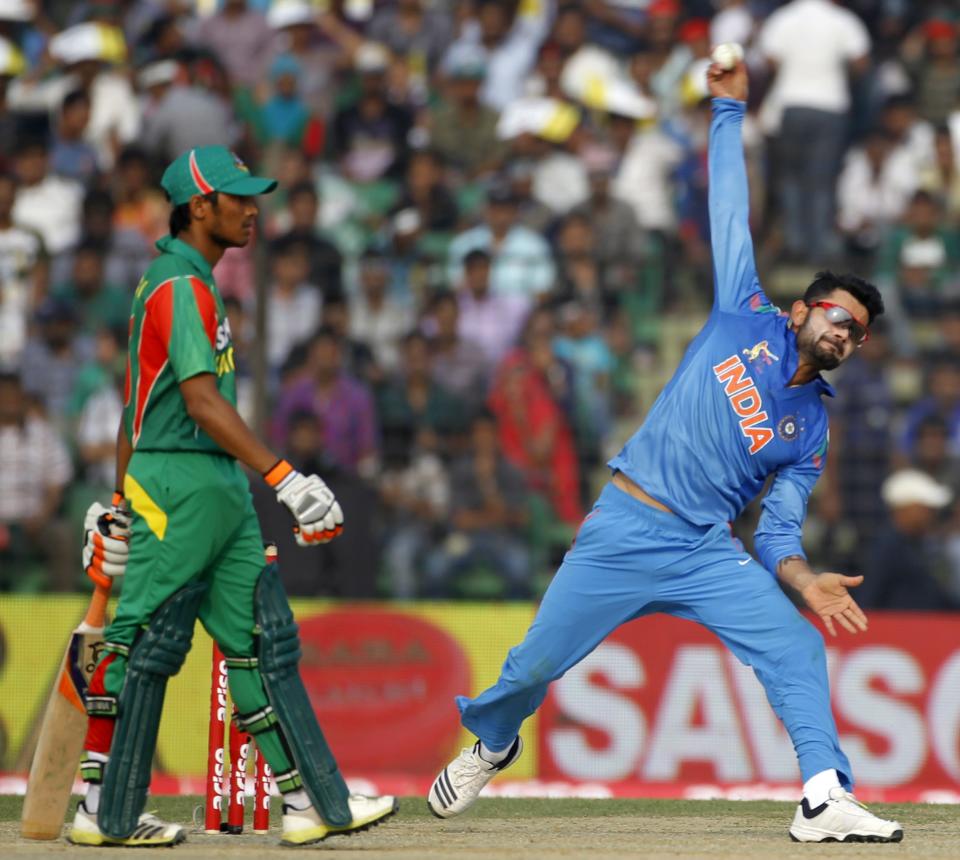 India's captain Virat Kohli bowls as Bangladesh's Anamul Haque (L) watches during their Asia Cup 2014 one-day international (ODI) cricket match in Fatullah February 26, 2014.