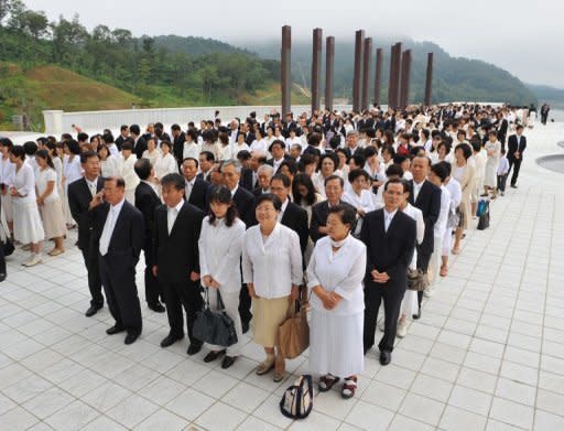 Unification Church devotees wait in line to mourn the death of founder Sun Myung Moon in Gapyeong. Buses ferried mourners into the Gapyeong complex where a special altar bearing a giant portrait of Moon had been erected inside a stadium