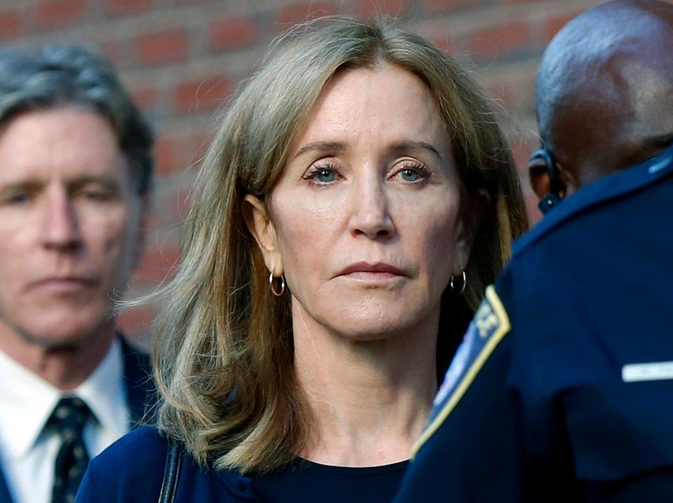 In this Sept. 13, 2019 file photo, actress Felicity Huffman leaves federal court in Boston with her brother Moore Huffman Jr., left, after she was sentenced in a nationwide college admissions bribery scandal. Huffman was sentenced to 14 days in federal prison in Dublin, Calif., but was released after serving 10 days.