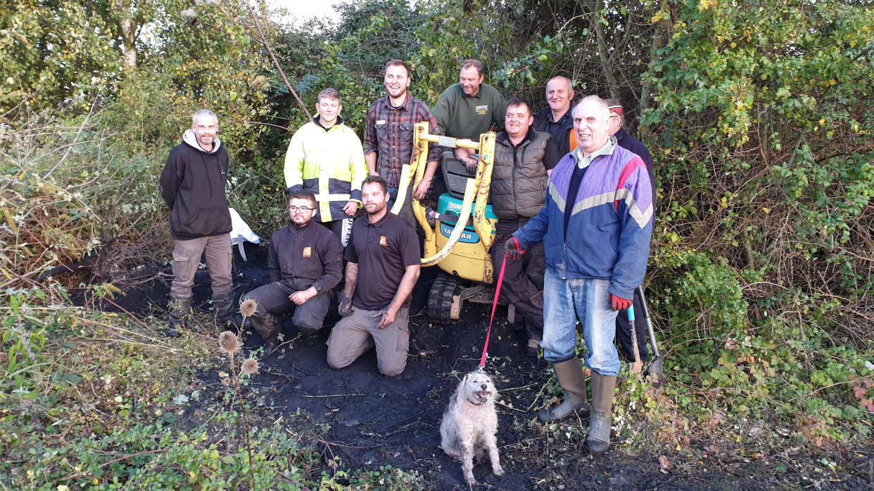 The rescue team with Bella the dog after she was freed (Picture: SWNS)
