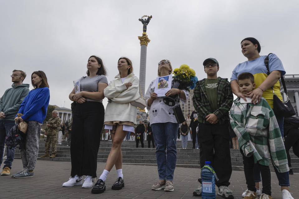 Ukrainians stand during the All-National minute of silence in commemoration of Ukrainian soldiers killed in the country's war against Russia on Independence square in Kyiv, Ukraine, Sunday, Oct. 1, 2023. Ukraine commemorates veterans and fallen soldiers on Sunday. The date of the annual Day of the Defenders was moved from 14th October as part of the reforms of the church calendar introduced by President Volodymyr Zelenskyy. (AP Photo/Alex Babenko)