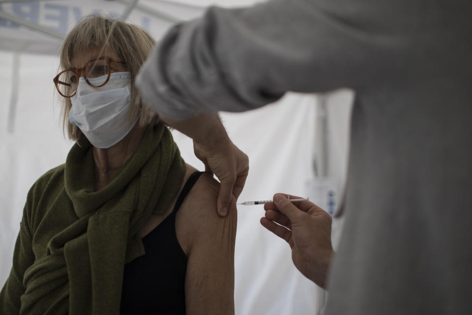 A woman receives the Pfizer COVID-19 vaccine at the Laveran Military Hospital in Marseille, southern France, Wednesday, April 7, 2021. Seven military hospitals also opened vaccination centers on Tuesday, operated by military and civilian staff, in an effort to inject up to 50,000 doses per week, the defense ministry said. (AP Photo/Daniel Cole)