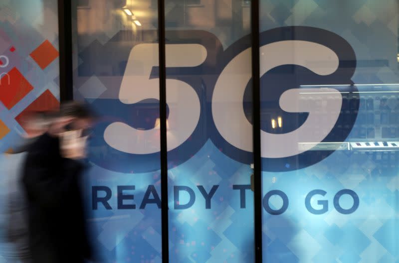 FILE PHOTO: A man walks past a 5G sign in Monaco