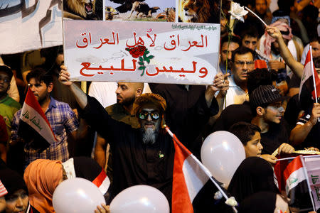 A supporter of Iraqi Shi'ite cleric Moqtada al-Sadr holds a banner that reads "Iraq for the Iraqi people and not for sale" during a protest calling for neutrality during the ongoing tensions between neighbouring Iran and the USA, at Tahrir square in Baghdad, Iraq May 24, 2019. REUTERS/Khalid Al-Mousily