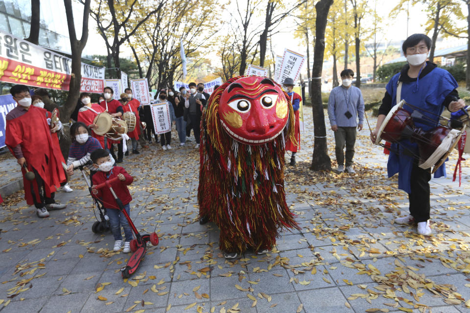 Workers wearing face masks to help protect against the spread of the coronavirus perform as they march during a rally to demand better working conditions in Seoul, South Korea, Saturday, Nov. 14 , 2020. (AP Photo/Ahn Young-joon)