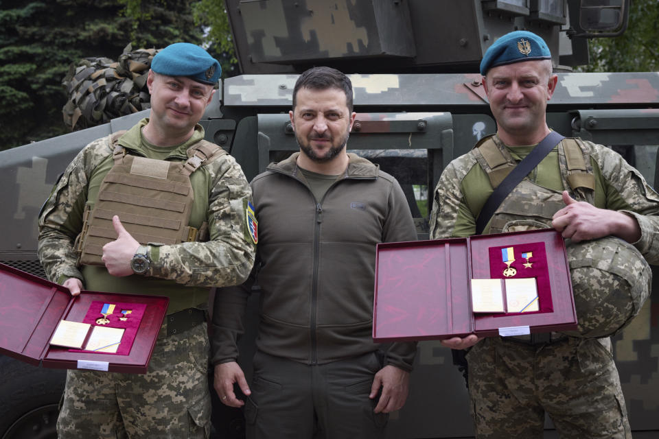 In this photo provided by the Ukrainian Presidential Press Office, Ukrainian president Volodymyr Zelenskyy, centre, poses for photo with soldiers after an awarding ceremony as he visits the Donetsk region, Ukraine, Tuesday, May 23, 2023. (Ukrainian Presidential Press Office via AP)