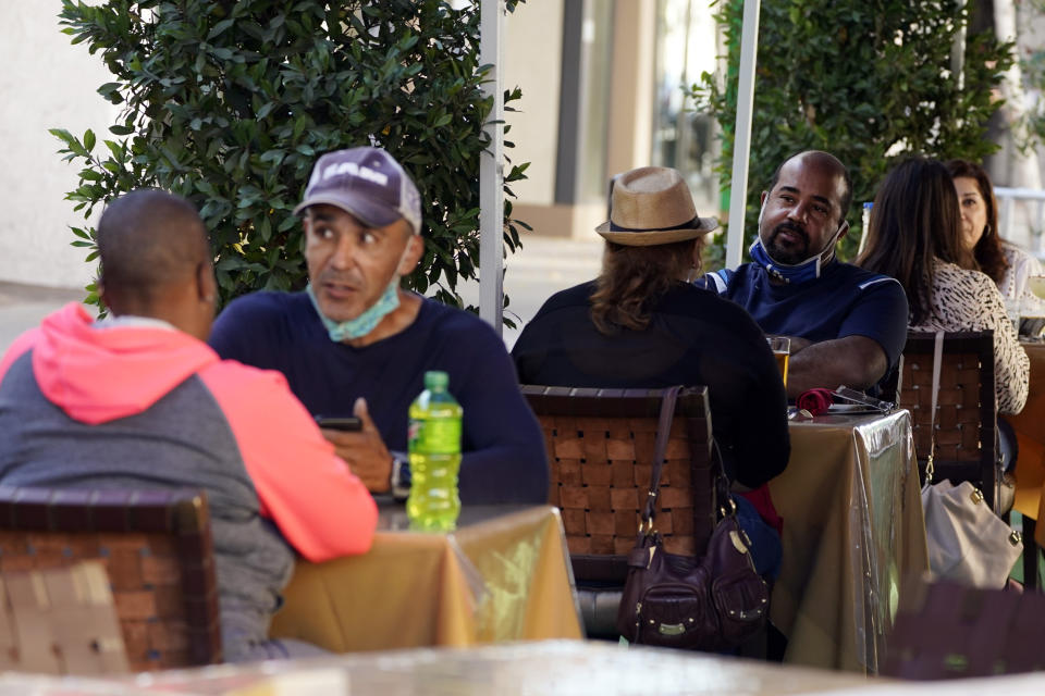 *** Hold for Story *** Patrons eat lunch at an outdoor eating space Tuesday, Dec. 1, 2020, in Pasadena, Calif. Pasadena has become an island in the center of the nation's most populous county, where a surge of COVID-19 cases last week led to a three-week end to outdoor dining and California's first stay-home order since the pandemic began to spread across the state in March. (AP Photo/Marcio Jose Sanchez)