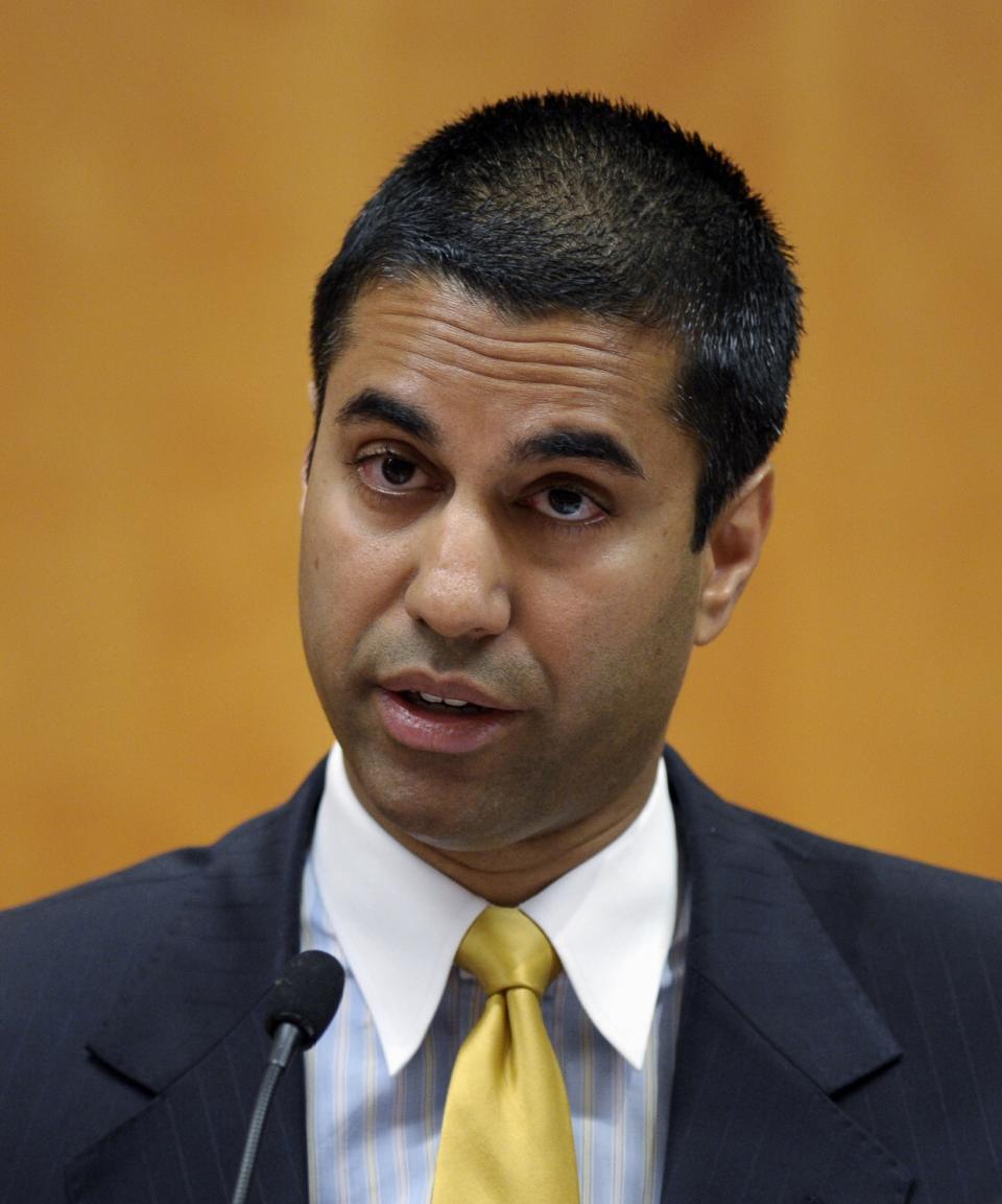 File - In this Aug. 9, 2013 file photo, FCC Commissioner Ajit Pai presents his dissent during a Federal Communications Commission (FCC) hearing at the FCC in Washington. Pai is asking the nation’s largest hotel chains whether they require guests to dial 9 before 911 in the wake of a Texas girl’s struggle to call for help while her mother was being stabbed.(AP Photo/Susan Walsh, file)