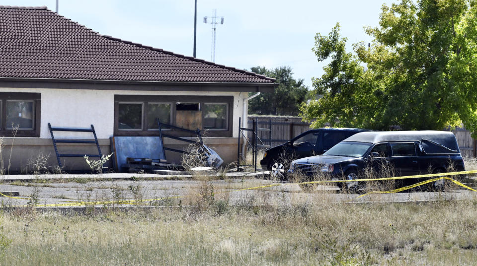 A hearse and debris can be seen at the rear of the Return to Nature Funeral Home in Penrose, Colo. Thursday, Oct. 5, 2023. Authorities said Thursday they were investigating the improper storage of human remains at a southern Colorado funeral home that performs “green” burials without embalming chemicals or metal caskets. (Jerilee Bennett/The Gazette via AP) /The Gazette via AP)