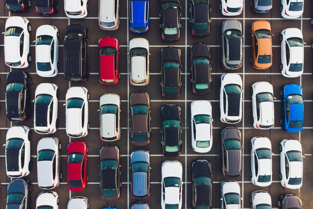 Cars are lined up in parking spots.