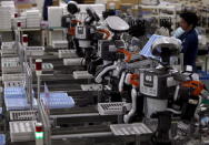 Humanoid robots work side by side with employees in the assembly line at a factory of Glory Ltd., a manufacturer of automatic change dispensers, in Kazo, north of Tokyo, Japan, in this July 1, 2015 file photo. REUTERS/Issei Kato/Files