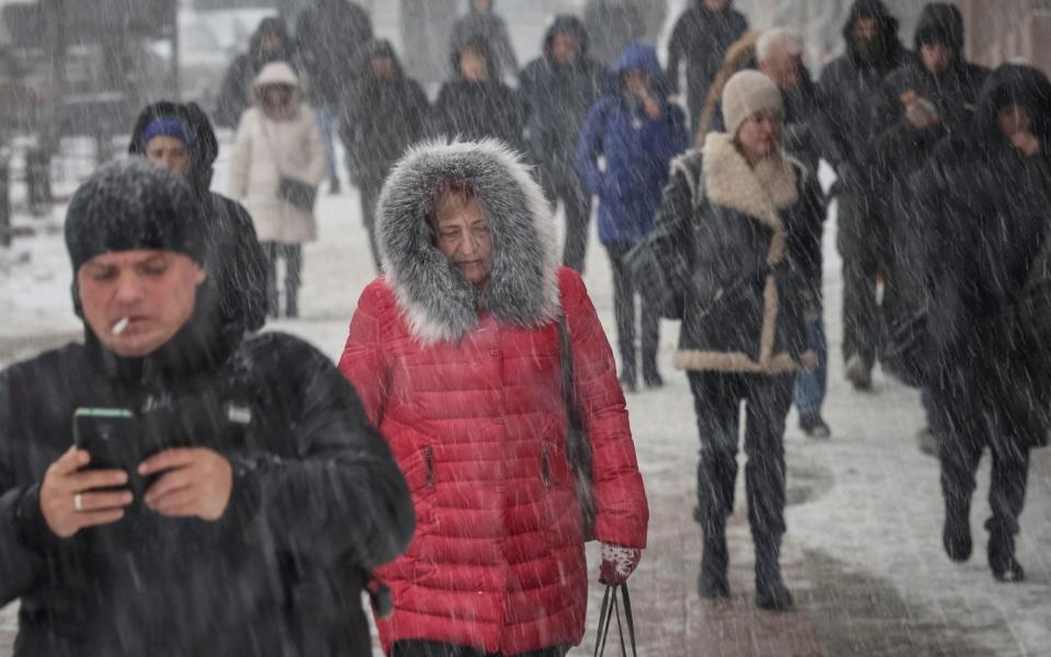 People walk down a street amid a snowfall as Russia's invasion of Ukraine continues, in central Kyiv - REUTERS/Gleb Garanich 