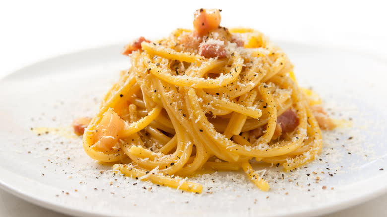 white plate of pasta carbonara