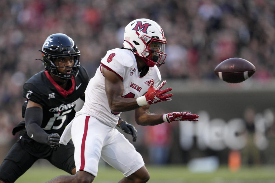 Miami (Ohio) running back Kevin Davis (8) makes a catch against Cincinnati defensive back Taj Ward (15) during the first half of an NCAA college football game, Saturday, Sept. 16, 2023, in Cincinnati. (AP Photo/Jeff Dean)