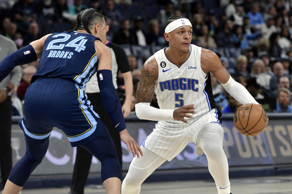 Orlando Magic forward Paolo Banchero (5) handles the ball against Memphis Grizzlies forward Dillon Brooks (24) in the first half of an NBA basketball game Tuesday, March 28, 2023, in Memphis, Tenn. (AP Photo/Brandon Dill)