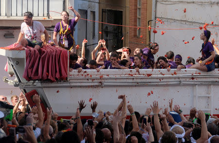 Revellers on a truck throw tomatoes into the crowd during the annual "Tomatina" festival in Bunol, near Valencia, Spain, August 29, 2018. REUTERS/Heino Kalis