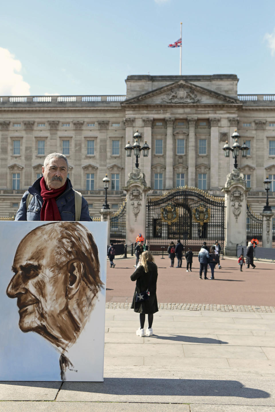 Artist Kaya Mar holds a portrait he has painted of the Duke of Edinburgh outside Buckingham Palace, London, Monday, April 12, 2021. Britain's Prince Philip, the irascible and tough-minded husband of Queen Elizabeth II who spent more than seven decades supporting his wife in a role that mostly defined his life, died on Friday. (Luciana Guerra/PA via AP)