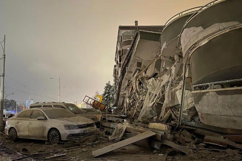 Damaged vehicles sit parked in front of a collapsed building following an earthquake in Diyarbakir, southeastern Turkey, (AP)