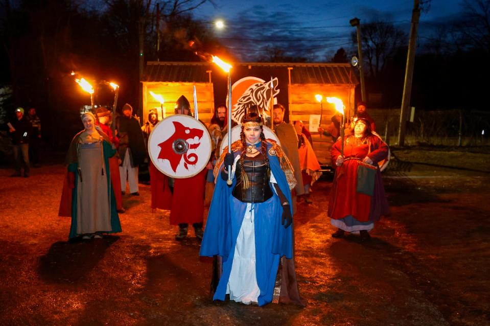 During the opening night ceremony at the Michigan Nordic Fire Festival in Charlotte, Cassie Truskowski, of Grand Rapids, who was dressed and paying tribute to Freya, the Norse goddess of love and fertility, starts to lead members of the Viking Vulksgaard as they carry a Viking ship toward the crowd gathered to watch it burn at the festival at the Eaton County Fairgrounds in Charlotte on Friday, Feb. 24, 2023.