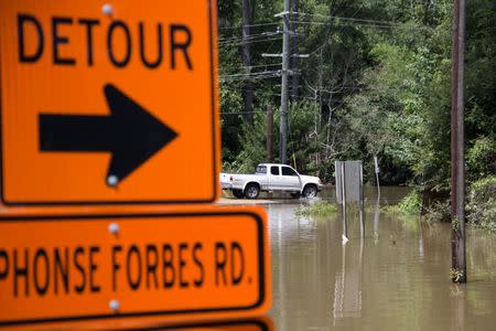 A truck takes a detour through a flooded street in Greenwell Springs, Louisiana. REUTERS/Jeffrey Dubinsky