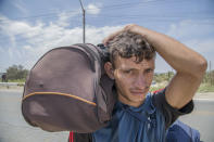 <p>José Cordoba, 20 years old, of Yaracuy, Venezuela, walks along the Panamericana route towards Lima on Aug. 16, 2018 in Tumbes, Peru. (Photo: Manuel Medir/Getty Images) </p>