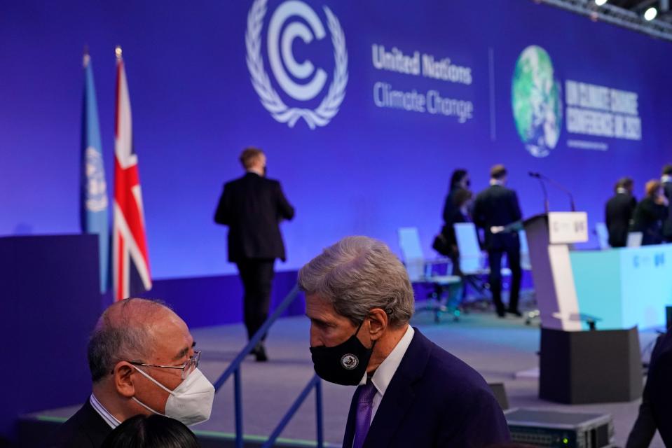 China's chief negotiator Xie Zhenhua, left, talks with John Kerry, United States Special Presidential Envoy for Climate, right, during a stocktaking plenary session at the COP26 U.N. Climate Summit in Glasgow, Scotland, Saturday, Nov. 13, 2021. Going into overtime, negotiators at U.N. climate talks in Glasgow are still trying to find common ground on phasing out coal, when nations need to update their emission-cutting pledges and, especially, on money.