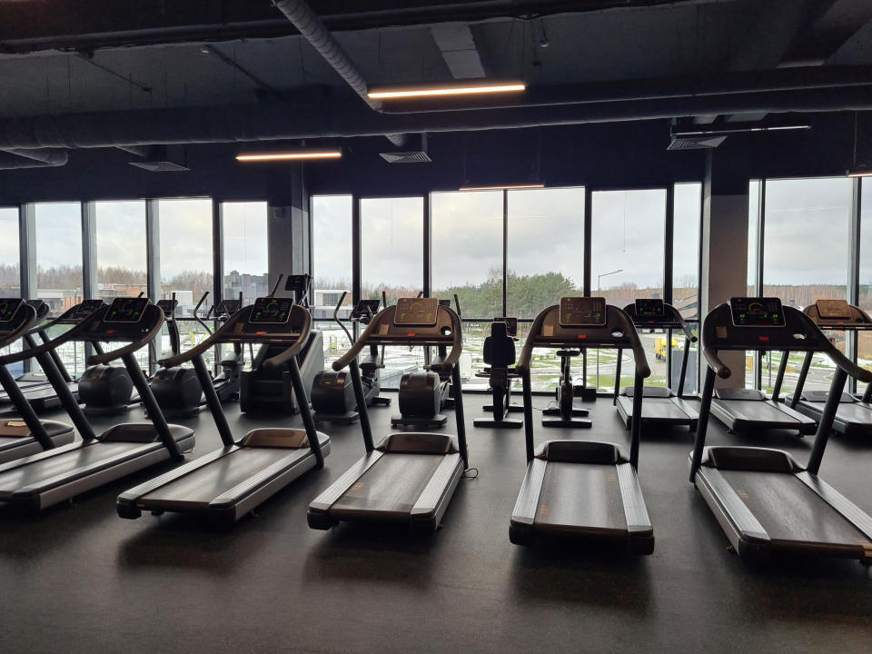 A modern gym with various treadmills and exercise machines but nobody's there working out