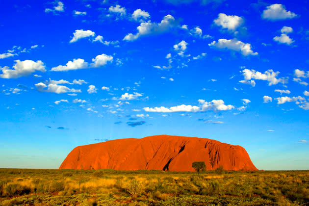 <b>Ayers Rock, Australien</b><br><br> Alleine für diesen Anblick lohnt es sich, ans andere Ende der Welt zu reisen! Der Ayers Rock liegt im Herzen Australiens und gilt bei den Aborigines als einer der Kraftpunkte der Erde. Der riesige Sandstein Monolith steht für die Vergangenheit, die Gegenwart und die Zukunft und wird sich auch vom Weltuntergang unbeeindruckt zeigen. Schließlich besagt die Legende, dass er schon ewig existiert. (Foto: ddp)