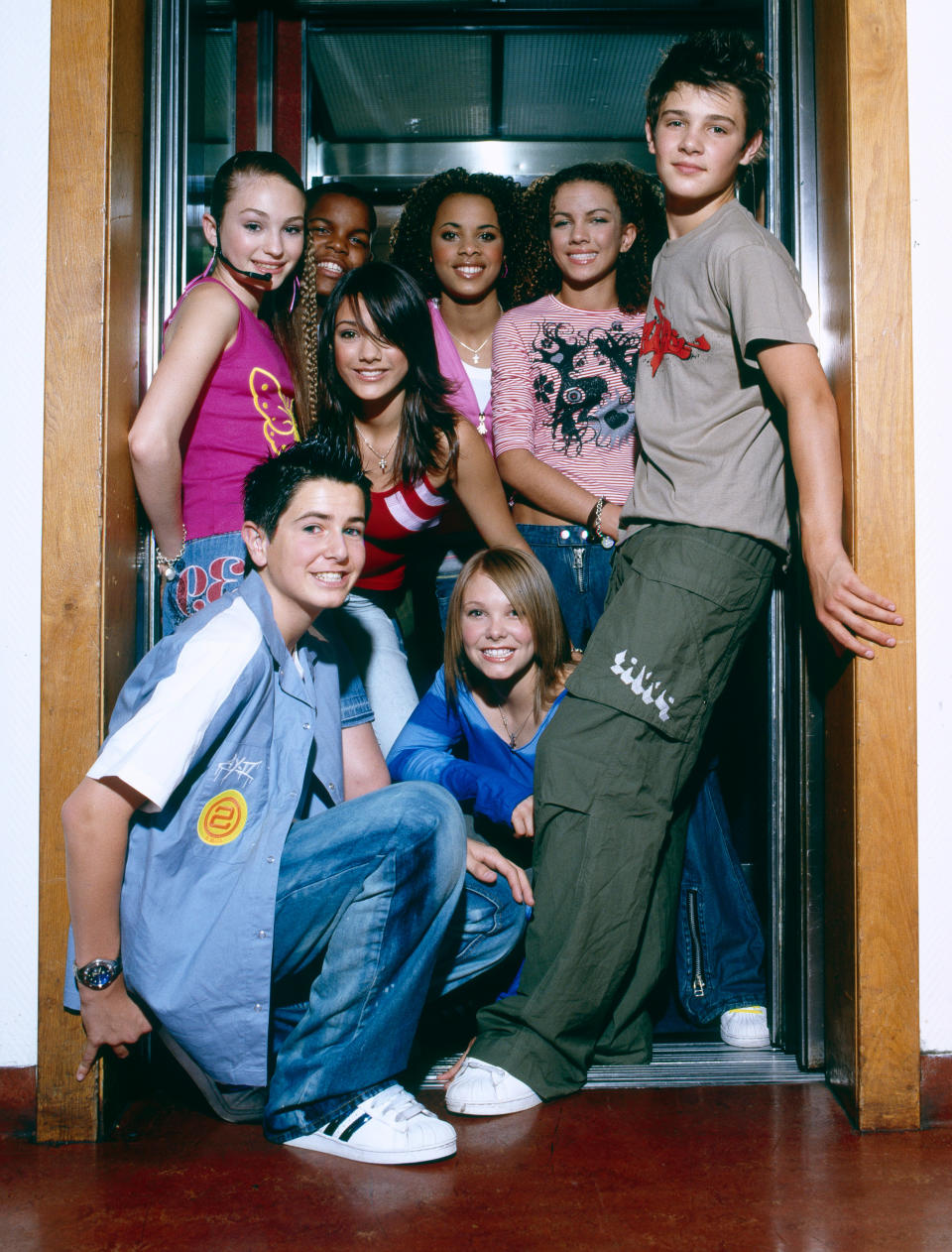 S Club Juniors backstage at a TV show, London, circa 2002. Left to right (back) Daisy Evans, Jay Asforis, Frankie Sandford, Rochelle Wiseman, Stacey McClean, Calvin Goldspink, (kneeling) Aaron Renfree, Hannah Richings. (Photo by David Tonge/Getty Images)