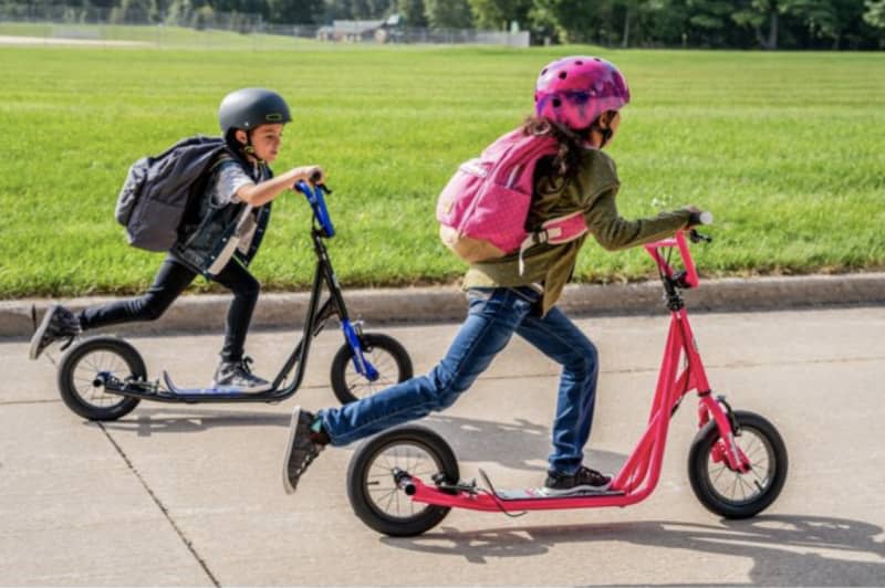 Two kids on black and pink Mongoose scooter