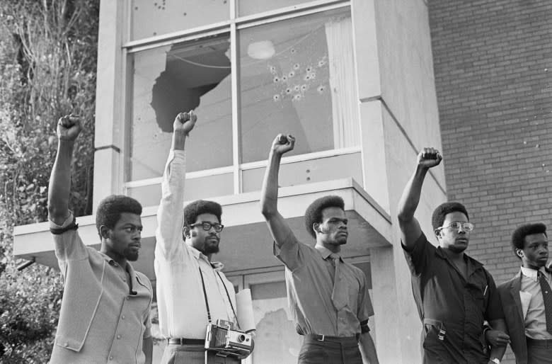 Demonstrators at Jackson State College give a Black Power salute outside bullet-riddled Alexander Hall women’s dormitory following memorial services for Phillip Gibbs and James Green, who were out down by police in May 1970. (Getty Images)