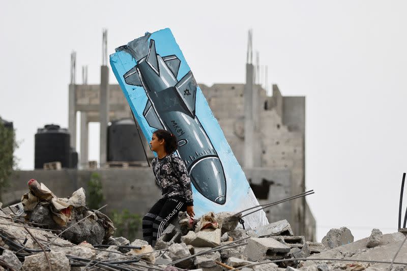 Artists draw graffiti on houses destroyed by Israel, in Deir Al-Balah