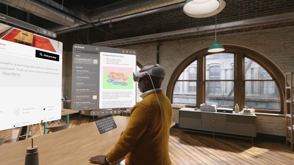 A person wearing Apple's Vision Pro in an office-like room.