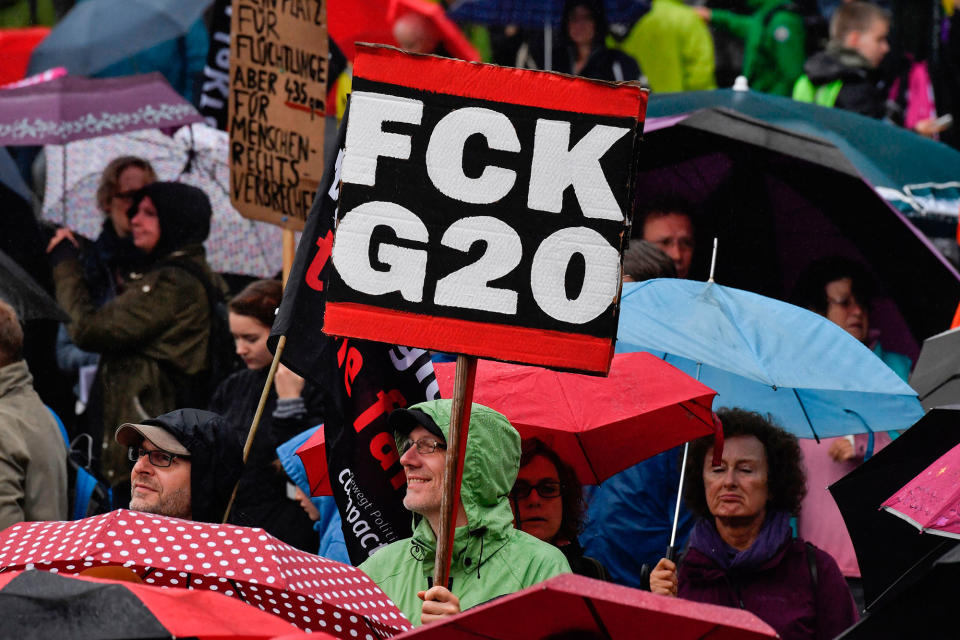 <p>Participants hold placards during a demonstration called by several NGOs ahead of the G20 summit in Hamburg on July 2, 2017. (John MacDougall/AFP/Getty Images) </p>