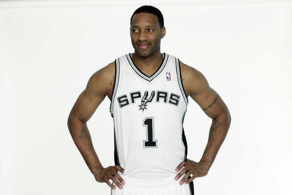 San Antonio Spurs&#39; Tracy McGrady waits to be photographed in his new Spurs basketball uniform on Wednesday, April 17, 2013, in San Antonio. McGrady was signed by the Spurs this week. (AP Photo/Eric Gay)