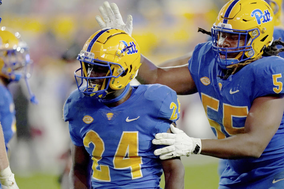 Pittsburgh offensive lineman BJ Williams (55) congratulates running back C'Bo Flemister (24) after he scored during the second half of an NCAA college football game against Louisville in Pittsburgh, Saturday, Oct. 14, 2023. (AP Photo/Matt Freed)