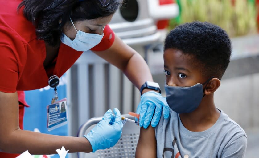 LOS ANGELES, CA NOVEMBER 3, 2021 - Seven-year-old Ari Alleyne receives the children's dose of the Pfizer Covid vaccine from RN Priya Meyer, Nursing Professional Development Mgr at Children's Hospital Los Angeles Wednesday morning, Nov. 3, 2021. (Al Seib / Los Angeles Times)