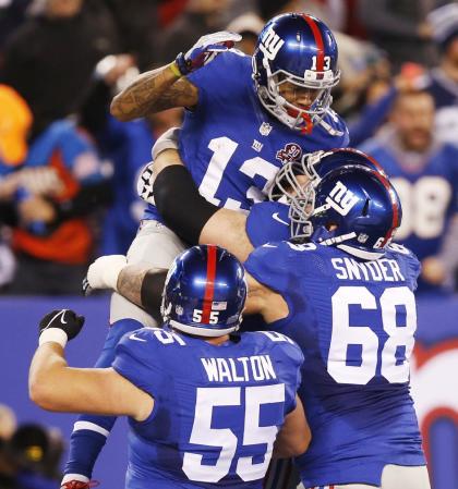 Odell Beckham (13) celebrates with teammates after making a touchdown catch against the Cowboys. (AP)