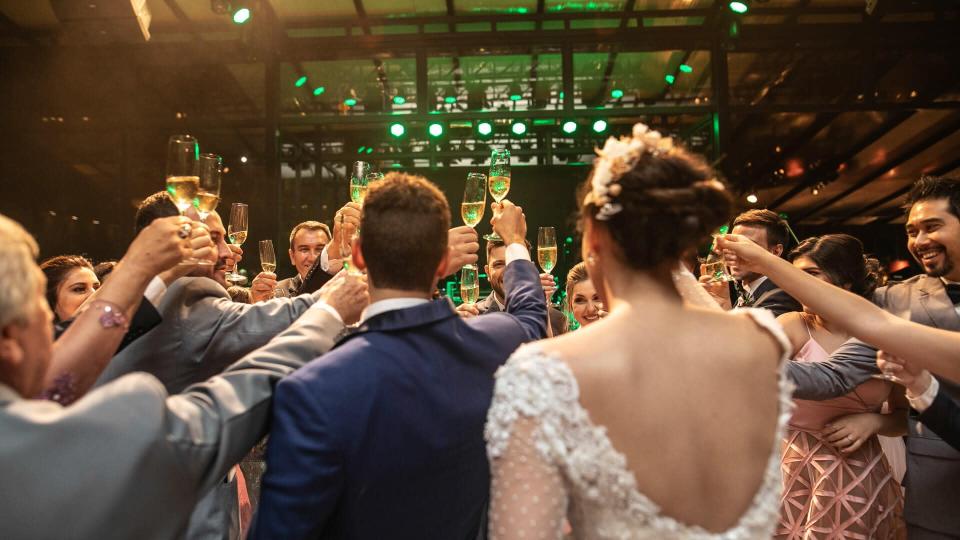 Bride, groom and wedding guests making a toast.