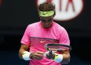 Rafael Nadal of Spain looks at the bandages on his hand after missing a shot to Tomas Berdych of the Czech Republic during their men's singles quarter-final match at the Australian Open 2015 tennis tournament in Melbourne January 27, 2015. REUTERS/Athit Perawongmetha