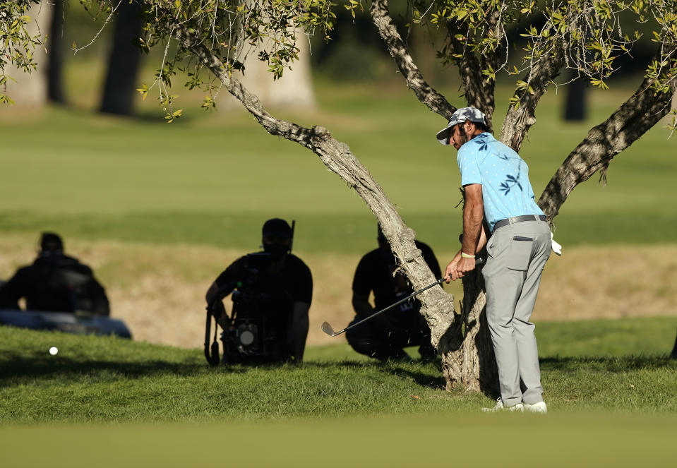 Max Homa hits his second shot from under a tree on the 10th hole during a playoff against Tony Finau in the final round of the Genesis Invitational golf tournament at Riviera Country Club, Sunday, Feb. 21, 2021, in the Pacific Palisades area of Los Angeles. (AP Photo/Ryan Kang)