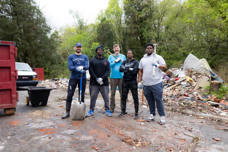 Garrett Thomson, far left, and a group of volunteers make strides in cleaning up illegal dump sites in the Macon-Bibb area.