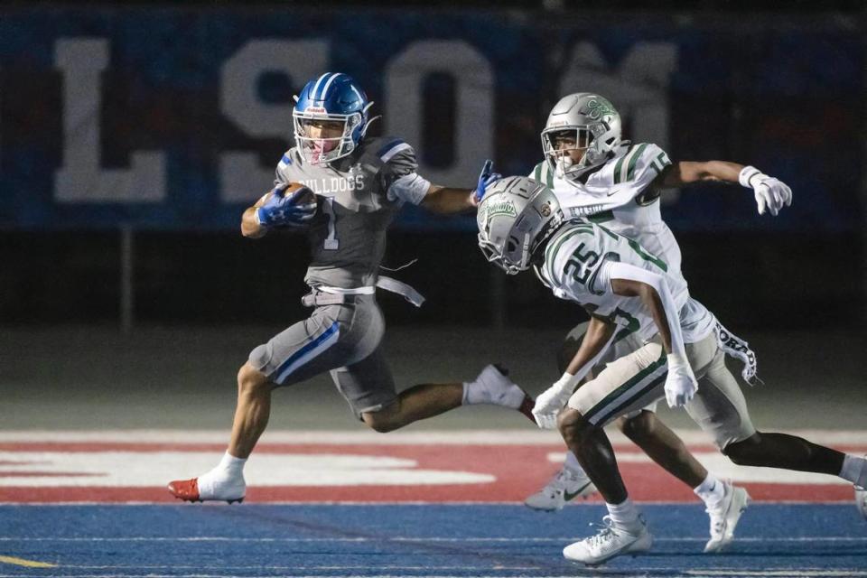The Folsom Bulldogs’ Abram Woodson (1) runs the ball before being tackled by the De La Salle Spartans’ Jaden Jefferson (15) in the first half of the game on Friday, Sept. 22, 2023, at Folsom High School in Folsom