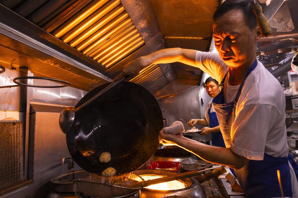 A chef fries abalone from South Africa at a restaurant in Hong Kong, Thursday, June 29, 2023. (AP Photo/Louise Delmotte)