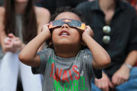 <p>John Deacon checks out the total solar eclipse wearing eclipse glasses in Union Square in New York City on Aug. 21, 2017. (Gordon Donovan/Yahoo News) </p>