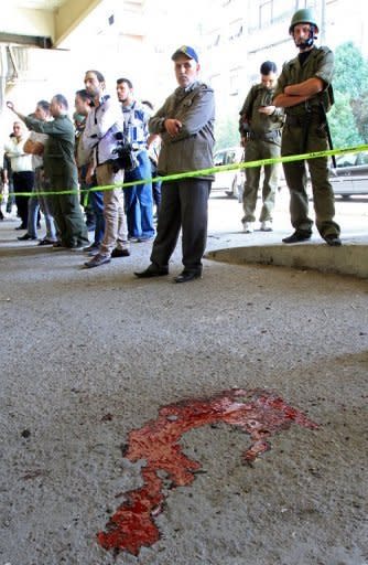 Blood stains the ground as Syrian security forces inspect the site of a blast in the central Midan district of Damascus