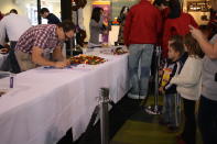 Children watch as Dave Camplin works on building a seal.